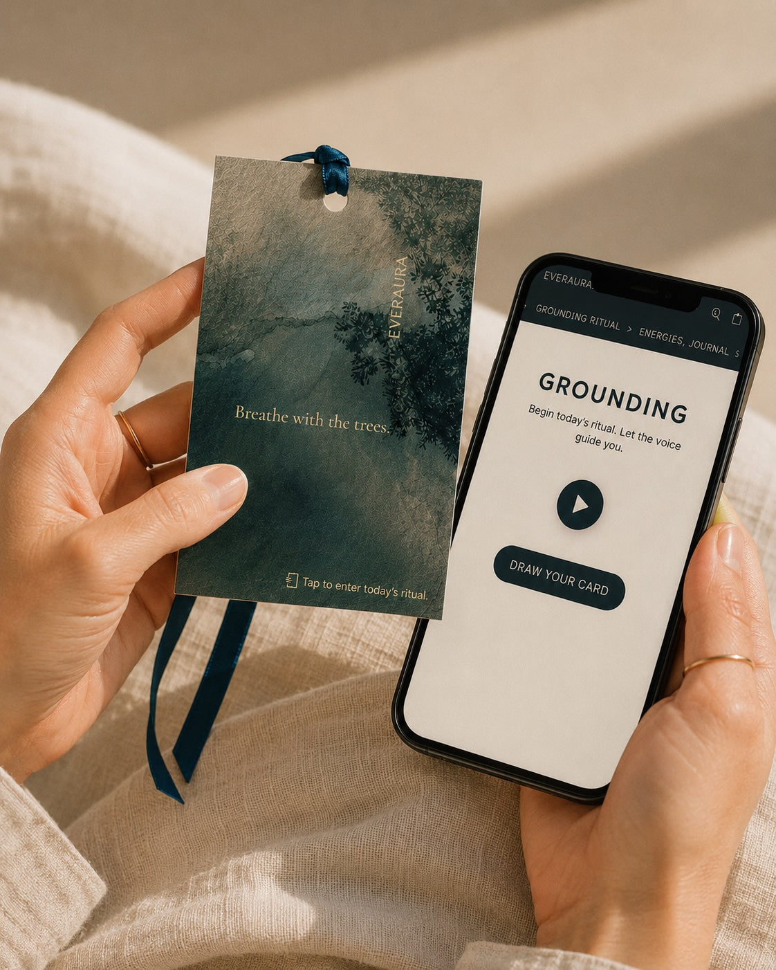 Hands holding an EverAura Grounding ritual card beside the guided meditation app — tap to begin today's one-minute nature meditation ritual.