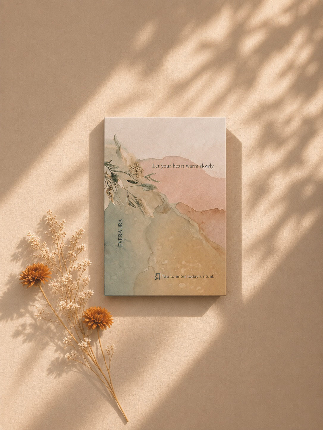 EverAura Radiant Heart ritual card, Let your heart warm slowly, styled on a warm wall in dappled light with dried flowers. A daily nature meditation and scent card.
