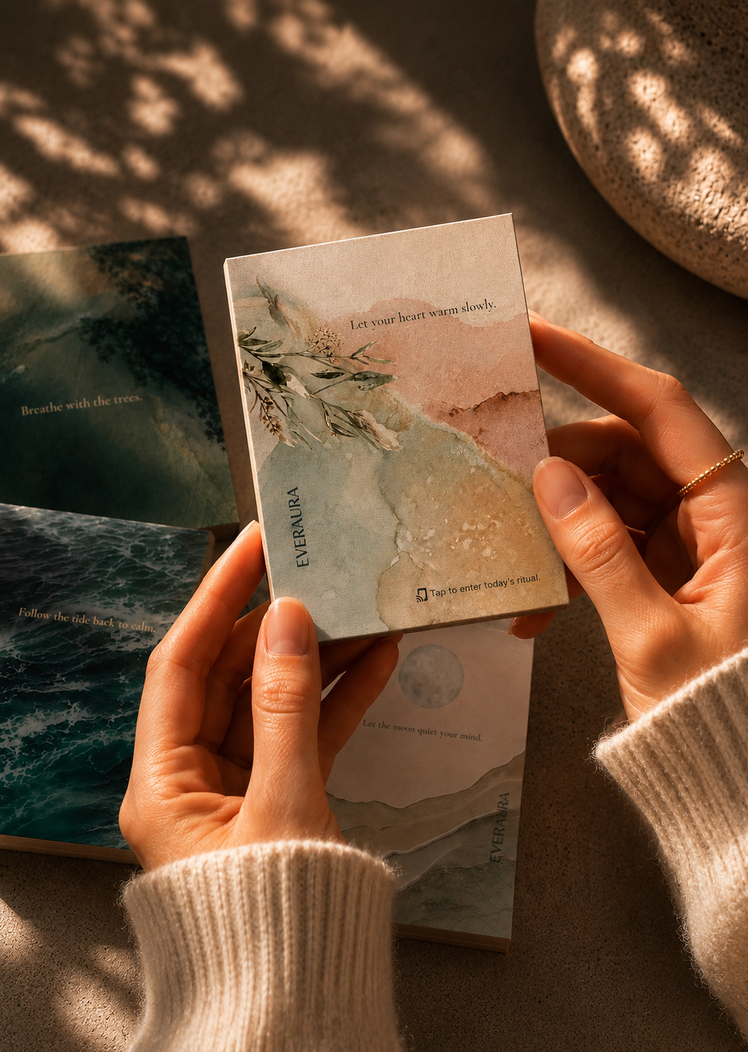 EverAura Four Energies Ritual Card Set, hands holding the Radiant Heart ritual card with the other cards resting nearby.